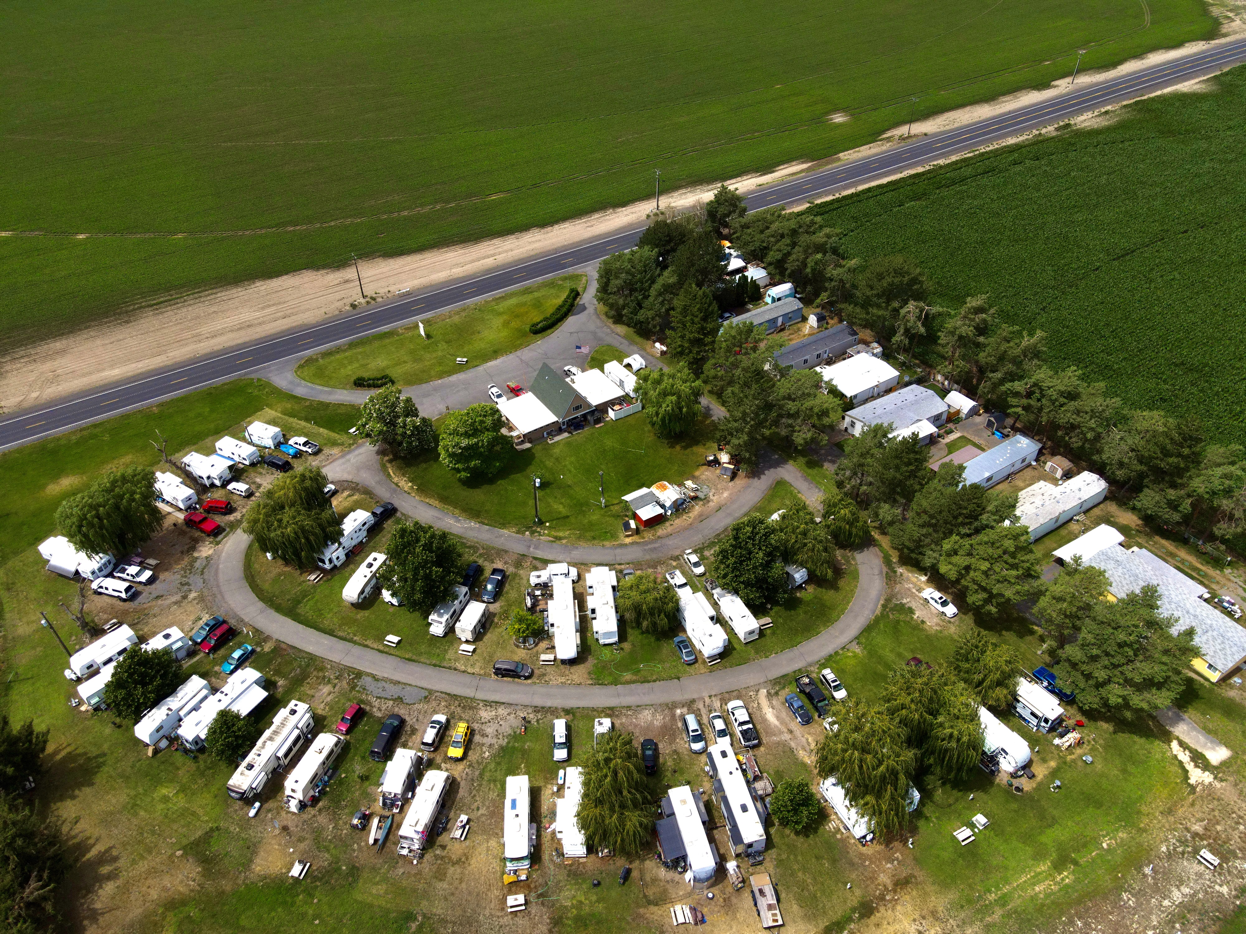 Oblique aerial of Willows Trailer Village showing the horseshoe loop drive, main office with flagpole, and RV sites beside the highway